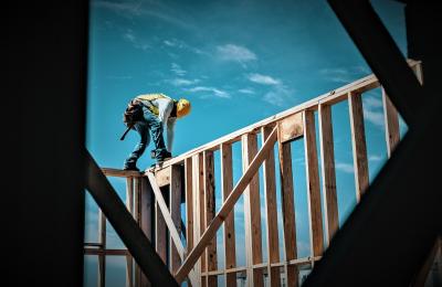 Construction worker on erected wood framing
